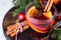 Kadr na szklankę wypełnioną świąteczną herbatą z cynamonem, pomarańczą i goździkami 