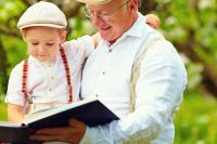 Na zdjęciu widać dziadka z wnukiem czytających książkę