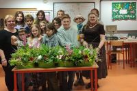 grupa młodzieży wraz z seniorami z grupy Aktywne Wrocławianki z gotowymi kompozycjami kwiatowymi