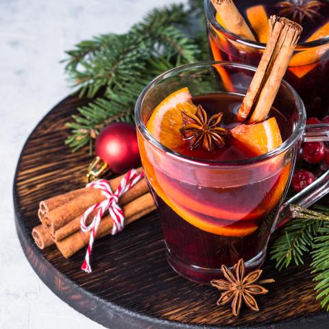 Kadr na szklankę wypełnioną świąteczną herbatą z cynamonem, pomarańczą i goździkami 
