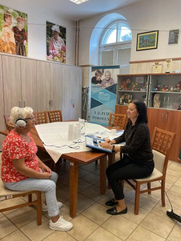 Dwie osoby w pomieszczeniu, badanie słuchu.