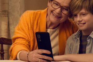 Na zdjęciu kobieta z wnuczkiem trzymający smartfon.