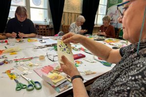 Na zdjęciu seniorzy w sali podczas warsztaów tworzenia wielkanocnych kartek świątecznych.