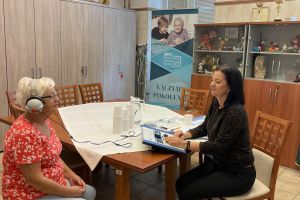 Dwie osoby w pomieszczeniu, badanie słuchu.