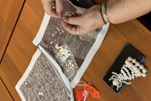 Aniłki z perełek ujecie na dłonie podczas nawlekania kuleczek.