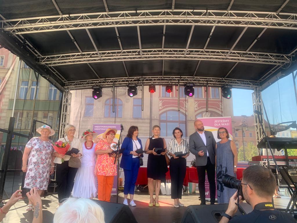 Na zdjęciu widzimy na scenie nagrodzonych statuetkami "Przyjaciel Seniorów"