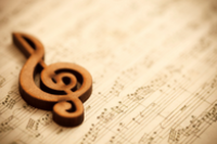 kartki z nutami oraz klucz muzyczny z drewna