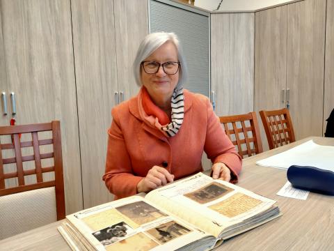 Na zdjęciu siedzi Pani Ewa Landsberg z pamiętnikiem rodzinnym