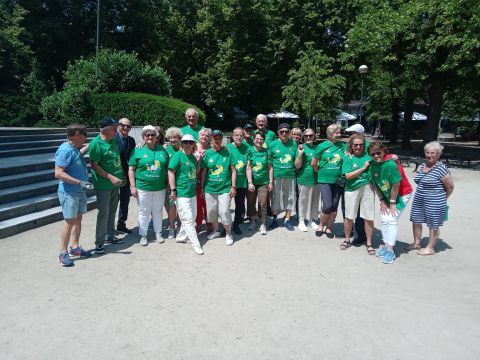 Na zdjęciu grupa osób w zielonych koszulkach w parku.