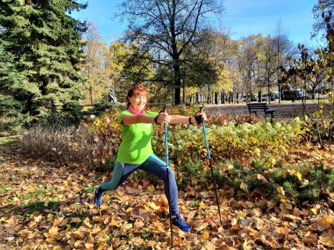 Na zdjęciu kobieta w stroju sportowym. Nordic walking z Teresą Tadeuszyk w parku.