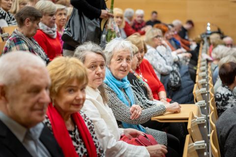 Seniorzy w sali konferencyjnej-wykładowej. 