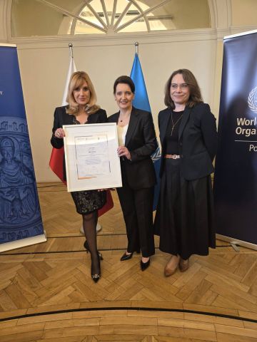 Trzy kobiety, jedna z nich trzyma certyfikat. Pierwsza od lewej strony stoi Kamila Polańska WCS-WCRS, następnie Pełnomocnik Rządu do spraw Polityki Senioralnej Marzena Okła-Drewnowicz oraz Patrycja Karpicz Dyrektor Miejskiego Centrum Usług Socjalnych we Wrocławiu.