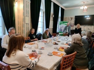 Uczestnicy 9 edycji Szkoły Liderów siedzący przy długim stole w sali wykładowej.