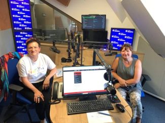 Dwie osoby siedzące w studiu radiowym.