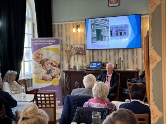 Mój pierwszy seans filmowy, zdjęcie prowadzącego i pełnej sali osób.