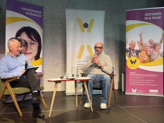 Stanisław Dzierniejko i Janusz Chabior siedzą na krzesłach na scenie.