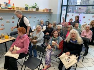 Seniorzy siedzący na krzesłach w centrum.