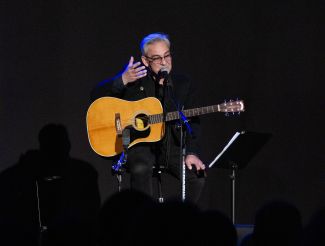 Na zdjęciu Robert Gonera z gitarą na scenie.