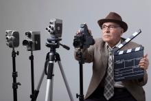 obrazek wprowadzający senior w kapeluszu siedzi za kamerami filmowymi na kliszę 