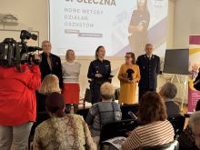 Zdjęcie przedstawia kilka osób na środku sali, podczas debaty społecznej. 