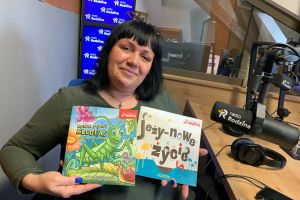 Na zdjęciu Pani Ewa trzymająca dwie książeczki dla dzieci.