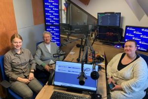 Na zdjęciu trzy panie w różnym wieku siedzące w studiu radiowym radia rodzina.