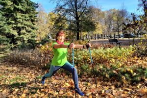 Na zdjęciu kobieta w stroju sportowym. Nordic walking z Teresą Tadeuszyk w parku.