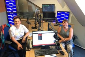 Dwie osoby siedzące w studiu radiowym.