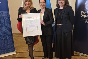 Trzy kobiety, jedna z nich trzyma certyfikat. Pierwsza od lewej strony stoi Kamila Polańska WCS-WCRS, następnie Pełnomocnik Rządu do spraw Polityki Senioralnej Marzena Okła-Drewnowicz oraz Patrycja Karpicz Dyrektor Miejskiego Centrum Usług Socjalnych we Wrocławiu.