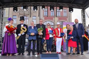 Grupa ludzi na scenie, od prawej Prezydent Wrocławia Jacek Sutryk, Dorota Feliks Dyrektor WCRS i laureaci tytułu Przyjaciela Seniorów. 
